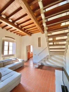 ein Wohnzimmer mit einem Sofa und einer Treppe in der Unterkunft Berenice Housing in Prato