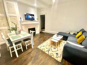 ein Wohnzimmer mit einem blauen Sofa und einem Tisch in der Unterkunft Maison individuelle atypique sur 2 étages in Bar-sur-Aube + 2 Fotos