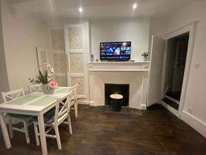 ein Esszimmer mit Tisch und Kamin in der Unterkunft Maison individuelle atypique sur 2 étages in Bar-sur-Aube