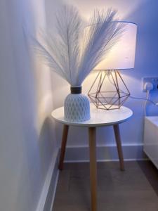 a blue and white vase on a table with a lamp at Modern 1-bed Duplex+Balcony in Manchester