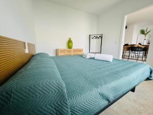 a large bed with a green comforter in a bedroom at Villa Don Paco in Las Negras