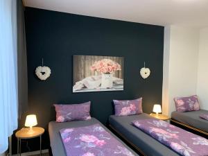 een kamer met 2 bedden en een vaas met bloemen bij Just Berlin - Wohnung für bis zu 12 Personen in Berlijn