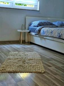 1 dormitorio con cama y alfombra en el suelo en Oaza mira en Osijek