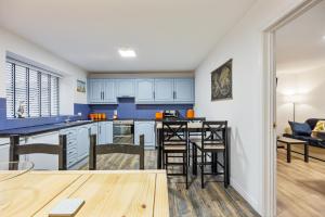 una cocina con armarios azules y taburetes de bar en Ballycastle Bolthole, en Ballycastle 26 fotos más