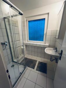 a bathroom with a shower and a sink and a window at E & N Apartments in Oberhausen