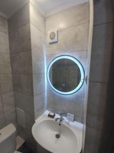 uma casa de banho com um lavatório e um espelho em Светлые апартаменты- Афины em Almaty