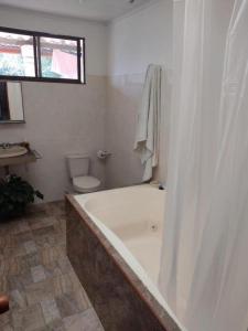 baño blanco con bañera y aseo en Casa Grande Guateque, en Guateque