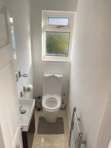 a small bathroom with a toilet and a window at Watford cottage holiday house in Abbots Langley