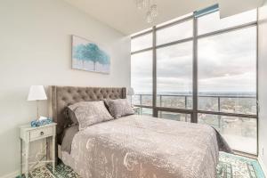 a bedroom with a bed and a large window at Spacious 3 Beds with Free Parking in Central Toronto in Mississauga