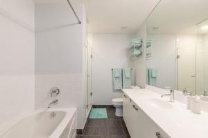 a white bathroom with two sinks and a toilet at Spacious 3 Beds with Free Parking in Central Toronto in Mississauga