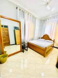 a bedroom with a bed and a large mirror at Tin apartment Tanga in Tanga