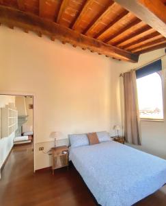een slaapkamer met een blauw bed en een raam bij Berenice Housing in Prato