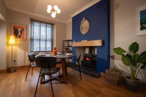 a dining room with a table and a blue wall at Fairmead in Ambleside