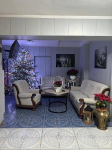 - un salon avec un arbre de Noël et un mobilier blanc dans l'établissement Ośrodek Vantur, à Księże Młyny