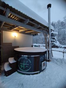 around hot tub in the snow with a roof at Farma u lesa in Hlinsko
