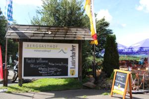 una señal para un restaurante con bandera y una señal en Berggasthof Hoherodskopf, en Schotten