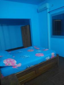 een slaapkamer met een bed met blauwe verlichting bij Résidence la Lobe in Kribi