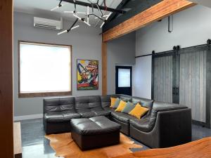 a living room with a leather couch and yellow pillows at Petaluma Warehouse Lofts unit E in Petaluma