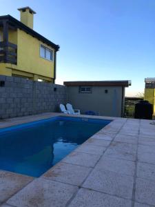una piscina frente a una casa en Cabañas Reina Mora en Villa Giardino