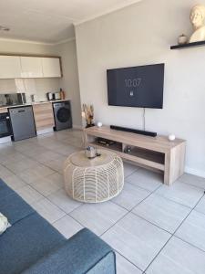 a living room with a flat screen tv on a wall at Prunell in midrand in Midrand