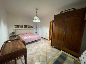 a bedroom with a pink bed and a wooden cabinet at Pà Blanc Apartments in Alghero