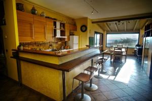 een keuken met een bar met krukken erin bij Suite de Roland in Taormina