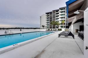 a swimming pool in front of a building at Florida Apartment with Balcony, Pool Access and Views in Panama City Beach