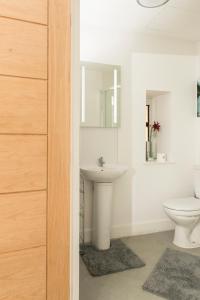 Baño blanco con lavabo y aseo en Cozy Studio Flat for Rent en Preston
