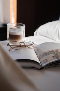 une paire de lunettes assise sur un livre dans l'établissement Palazi Apartments & Spa, à Nauders