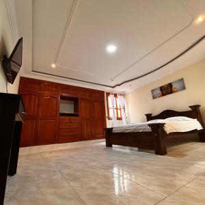 a bedroom with a bed and a television in it at Casa Hotel Los Fundadores in La Victoria