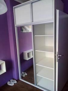 Obývací pokoj pro 1 či 2 hosty v soukromí في براغ: خزانة بيضاء مع باب زجاجي في غرفة