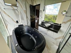 een badkamer met een zwart toilet en een wastafel bij Pousada Circuito dos Inconfidentes in Congonhas