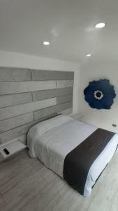 a bedroom with a bed with a blue flower on the wall at mirador samsara in La Calera