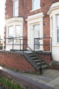 - un bâtiment en briques avec des escaliers en face dans l'établissement Cozy Studio Flat for Rent, à Preston