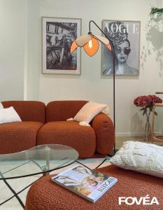 a living room with a couch and a floor lamp at Athéna in Caen