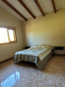 1 dormitorio con cama y ventana en El Retamo en San Carlos de Bariloche