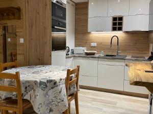 a kitchen with a table and a kitchen with white cabinets at Carène in Valloire