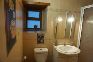 ein Badezimmer mit einem Waschbecken, einem WC und einem Spiegel in der Unterkunft Casa da Cantarinha in Fundão