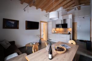 Il comprend une cuisine et un salon avec une table en bois. dans l'établissement Palazi Apartments & Spa, à Nauders