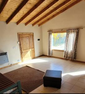 una stanza vuota con una grande finestra e una porta di El Retamo a San Carlos de Bariloche