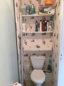 bagno con servizi igienici bianchi e scaffali di Maison avec terrasse et jardin à 600m de la plage a Berck-sur-Mer
