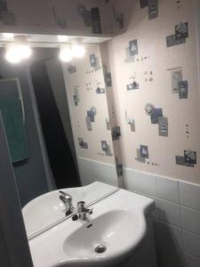 La salle de bains est pourvue d'un lavabo et d'un miroir. dans l'établissement Maison avec terrasse et jardin à 600m de la plage, à Berck-sur-Mer