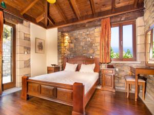 a bedroom with a bed and a stone wall at Falasarna Villas in Falasarna +32 photos