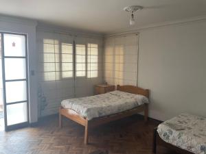 sypialnia z 2 łóżkami i oknem w obiekcie White House - Casa de interacción. w mieście Sucre
