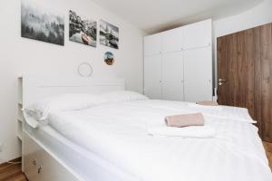 a white bedroom with a large white bed at Horský apartmán Temari 14 Klínovec in Loučná pod Klínovcem