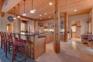 a large kitchen with a bar and wooden beams at Sundance Lodge -Mountain Home w Views of Palisades - Ski Shuttle, Pets okay! in Olympic Valley
