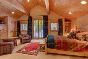 a bedroom with a bed and chairs in a room at Sundance Lodge -Mountain Home w Views of Palisades - Ski Shuttle, Pets okay! in Olympic Valley