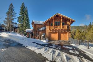 a log home in the snow with a driveway at Sundance Lodge -Mountain Home w Views of Palisades - Ski Shuttle, Pets okay! in Olympic Valley