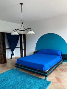 - une chambre avec un lit bleu et un tapis bleu dans l'établissement Tenuta Frasassi, à Collegiglioni
