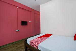 Habitación roja con cama con pared roja en OYO Flagship Hotel I stayz, en Madurai